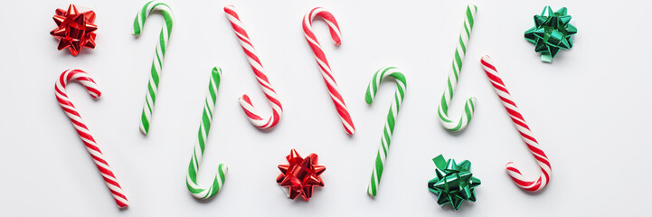 Candy Canes and lollipops with branches fir on a white background. Christmas postcard. Happy New Year concept. Top view. Flat lay