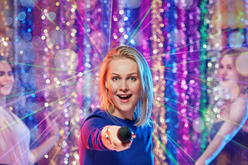 Portrait of happy pretty blonde having fun and singing at karaoke club