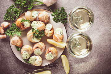 Escargots de Bourgogne - Snails with herbs butter on gray background. Top view