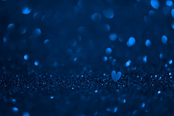 Blue heart on glittering paper with round bokeh. Valentine's Day and love concept. Banner, postcard, backgrounds. Copy space. With love.  Macro