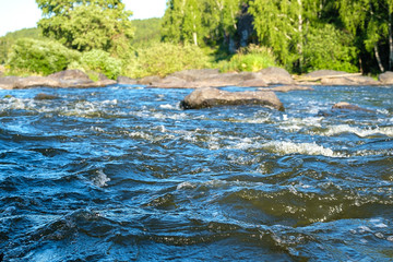 waves of a mountain river running on stone in the summertime background