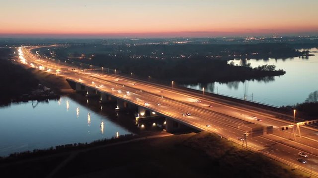 Evening traffic on the A6 highway that connects Amsterdam and the main land to the Flevoland polder with Almere and Lelystad cities in The Netherlands. Aerial shot.	