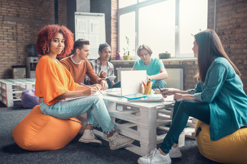 Group of students sitting at the table and discussing their group project