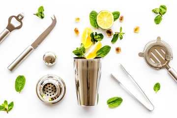 Bartender work desk with equipment and cocktail ingredietns Shaker, lime, ice on white background top-down pattern