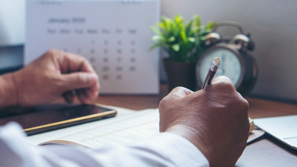 Calendar reminder event concept.Man hand planner or organizer writing on diary book.Student...