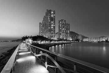 Seaside promenade and high rise residential building in Hong Kong city at dusk