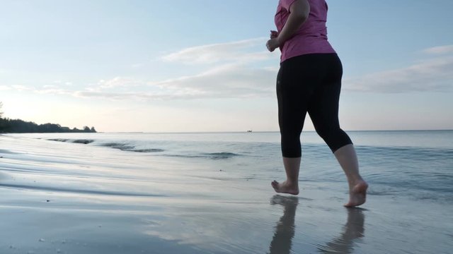 Rear view Asian women fat shape in exercise clothes Happy running In the beach in the morning. Health exercise Slow motion