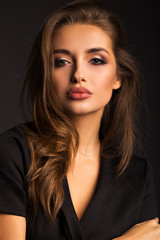 Fototapeta premium Portrait of a beautiful brunette on a gray isolated background. Luxurious girl with beautiful lips.