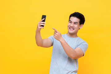 Young happy Asian man selfie with smartphone