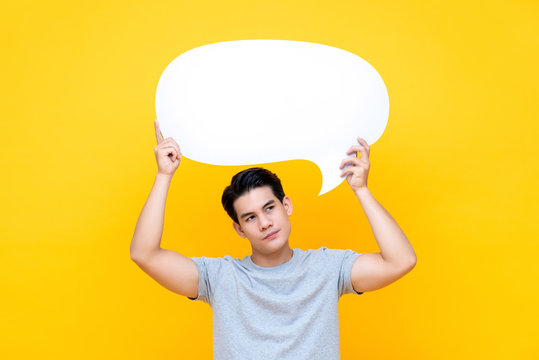 Unhappy bored young Asian man with empty speech bubble