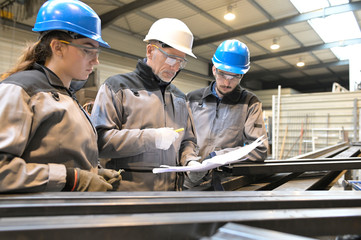 Steelwork instructor with young apprentice in workshop
