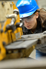 Young apprentice using steelworks machine