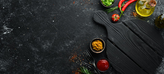 Dark cooking banner. Vegetables and spices on the kitchen table. Top view. Free space for your text. - obrazy, fototapety, plakaty