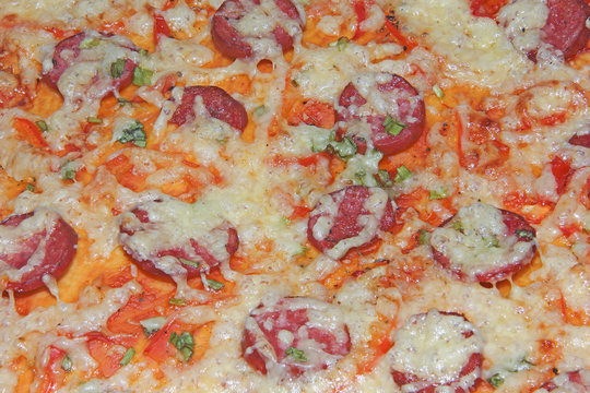 The texture of the finished pizza is the texture of the top layer with melted cheese and smoked sausage. The process of cooking a culinary dish.