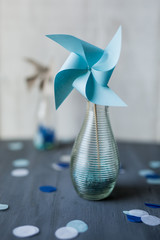 Windrad in Blau auf Holz in Vase aus Glas mit Konfetti - Zukunft, Wind, Freiheit, Nachhaltigkeit -...