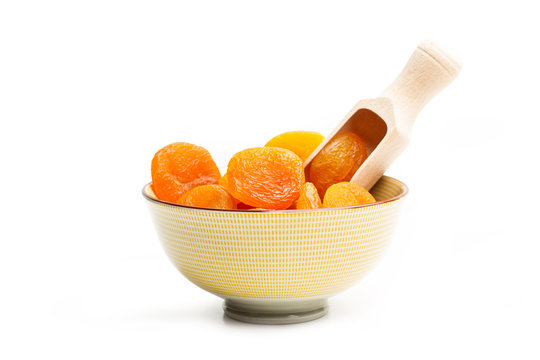 Albaricoque seco dentro de un cuenco sobre blanco aislado. Orejones. Vista de frente y de cerca. Copy space