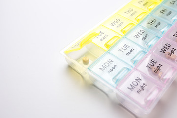 Organizer for medical pills on a white isolated background close-up. Organization of taking pills of the day.