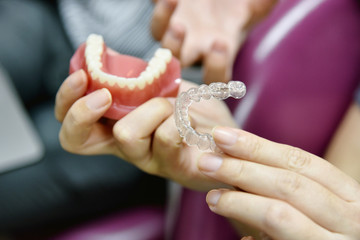 Inivisalign braces or aligner. Dentist advice how invisible orthodontics make beautiful teeth in dental clinic. - obrazy, fototapety, plakaty