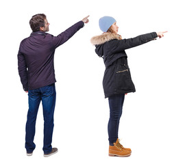 Naklejka premium Back view of couple couple in winter jackets pointing.