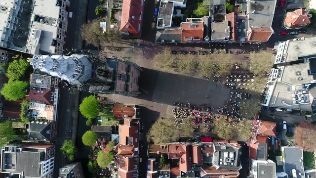 Aerial top down view of Long John tower located at the Lievevrouwe Kerkhof Square Amersfoort showing the old gothic bell tower and the plaza with people enjoying drinks 4k high resolutions quality