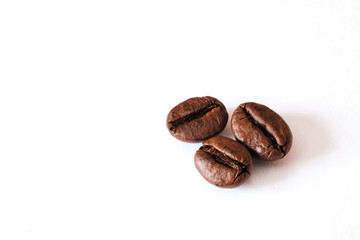 Coffee beans lie on a white sheet of paper