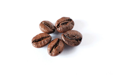 Coffee beans lie on a white sheet of paper