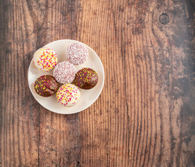  Flat lay of six cupcakes on a white plate on a wooden background with copy space