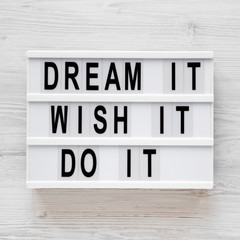 'Dream it, wish it, do it' words on a modern board on a white wooden background, top view. Overhead, from above, flat lay. Close-up.