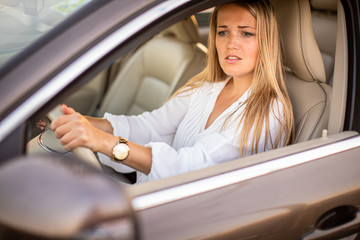 Pretty, young woman  driving a car -Invitation to travel. Car rental or vacation.