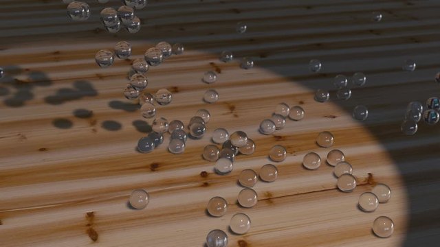 glass marbles falling onto a wooden ground, relaxing movement of golden spheres, 4k