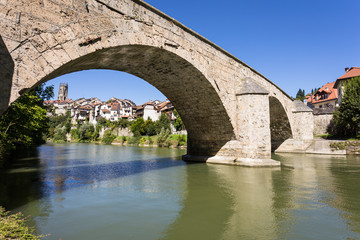 The old stone bridge over the Sarine river in Fribourg medieval old town on a sunny day in...