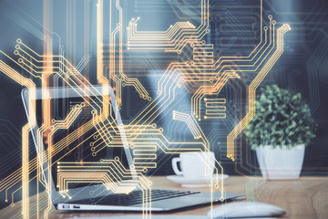 Computer on desktop in office with technology theme hologram. Multi exposure. Tech concept.