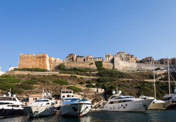 Luxury yachts anchored in front of the famous Bonifacio citadel in Corsica in France on a sunny...