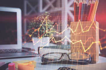 Financial chart hologram with glasses on the table background. Concept of business. Double exposure.