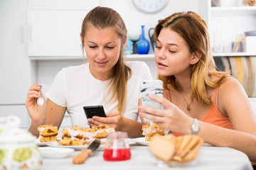 Obraz na płótnie Canvas females chatting on phone and drinking tea