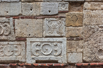 Аntique stone plates from Etruscans and the Romans built into the wall of a building in Montepulciano, Italy