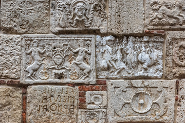 Аntique stone plates from Etruscans and the Romans built into the wall of a building in Montepulciano, Italy