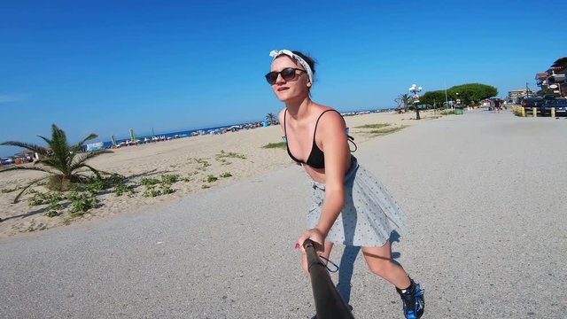 Selfie of roller skating girl on beach rollerblading on skates. Hipster girl in outdoor activities