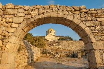 Fototapeta na wymiar Arch in ancient wall of Creek colony Chersonesos with the view of Saint Vladimir cathedral, Sevastopol, Crimea