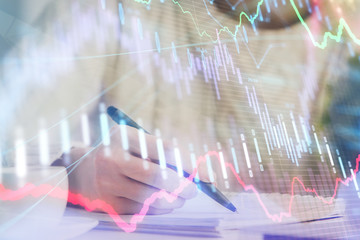 Forex chart displayed on woman's hand taking notes background. Concept of research. Multi exposure