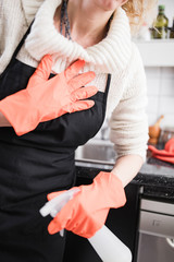 Woman having heart / chest pain and problems during house work in the kitchen.