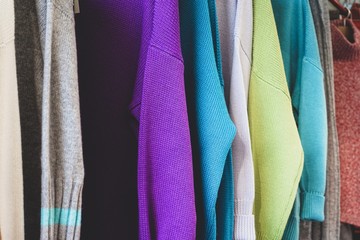 sweaters of different colors hanging