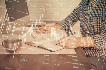 Double exposure of stock market chart with man working on computer on background. Concept of...