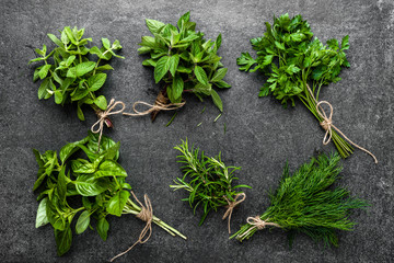 Collection of herbs, bunches of freshly harvested green herbs from the garden on dark background