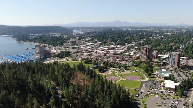 An aerial shot coming into Coeur d'Alene Idaho from the east over Tubbs Hill featuring some of the city, the lake and even the Spokane River.
