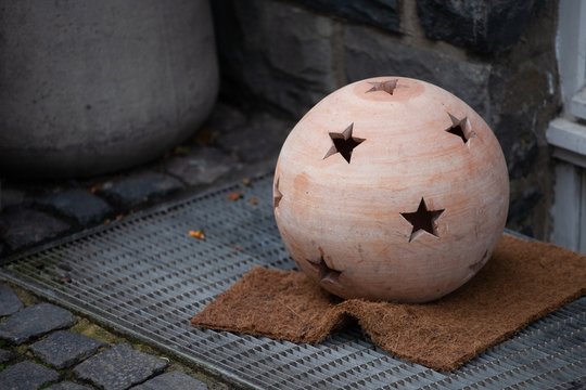 terracotta candle sphere with star shaped holes on ground