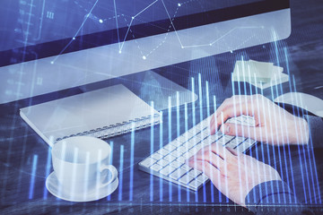 Multi exposure of graph with man typing on computer in office on background. Concept of hard work.