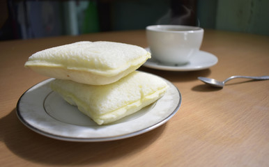 Coffee and bread on a wooden table in the morning