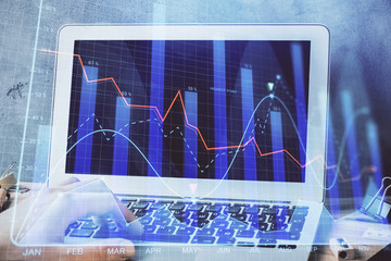 Forex graph with businessman working on laptop on background. Concept of hardworking. Multi...