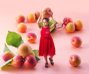 Fototapeta na wymiar Small girl holding big ripe apricot above her head and walking between large fruits.